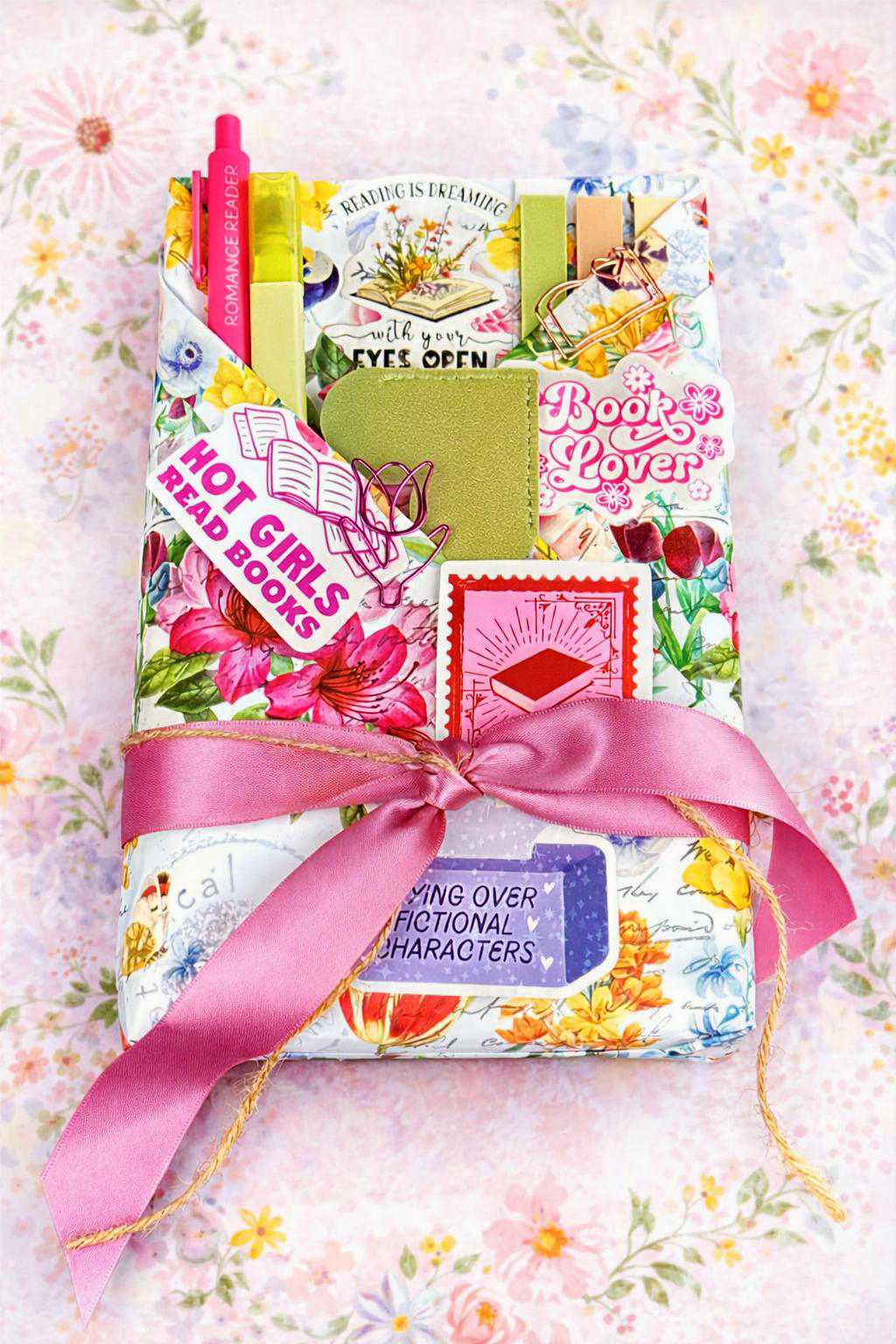 Colorful, floral wrapping paper around a book with cheerful, fun stickers and goodies.